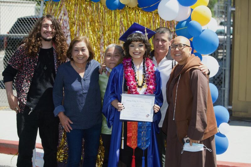 Alisha Foster, graduada de Gateway College and Career Academy, sostiene su diploma mientras posa con su familia en la graduación